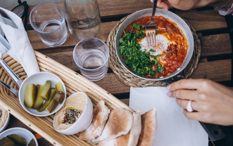 Shakshuka, Fried Eggs in Tomato Sauce on the Table. Street Restaurant